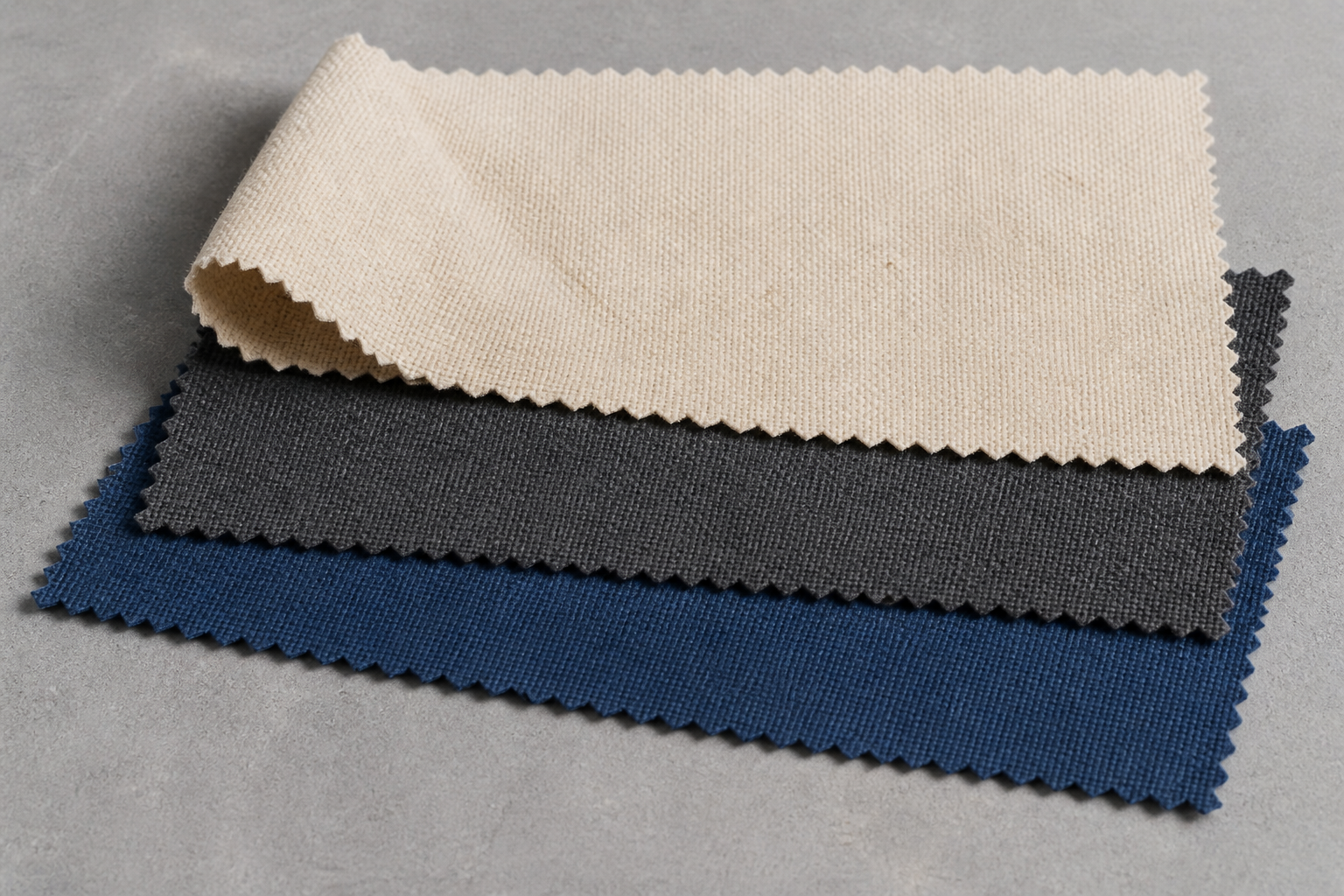 Natural, navy and charcoal canvas swatches in a material study