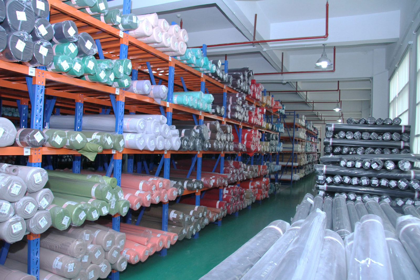 Organized rolls of bag fabric stored on industrial warehouse racking